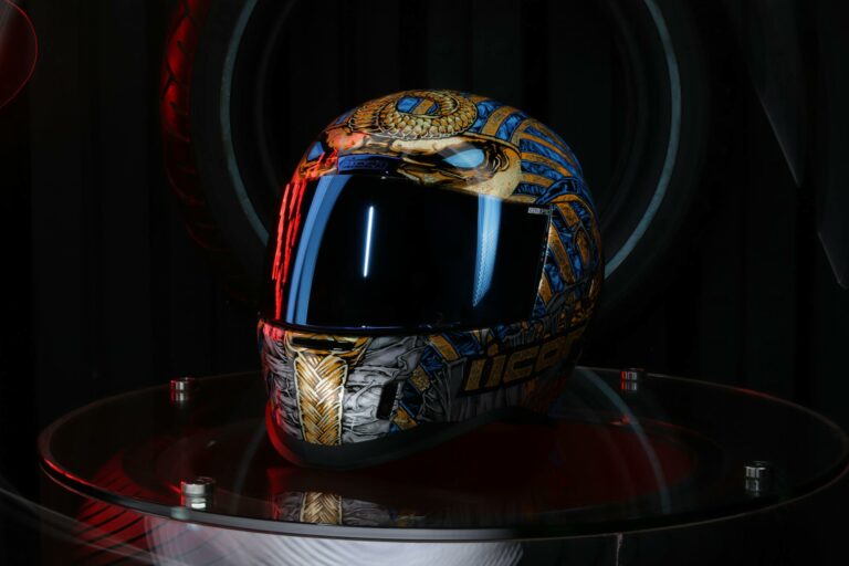 Artistic motorcycle helmet with vibrant colors and intricate design displayed indoors